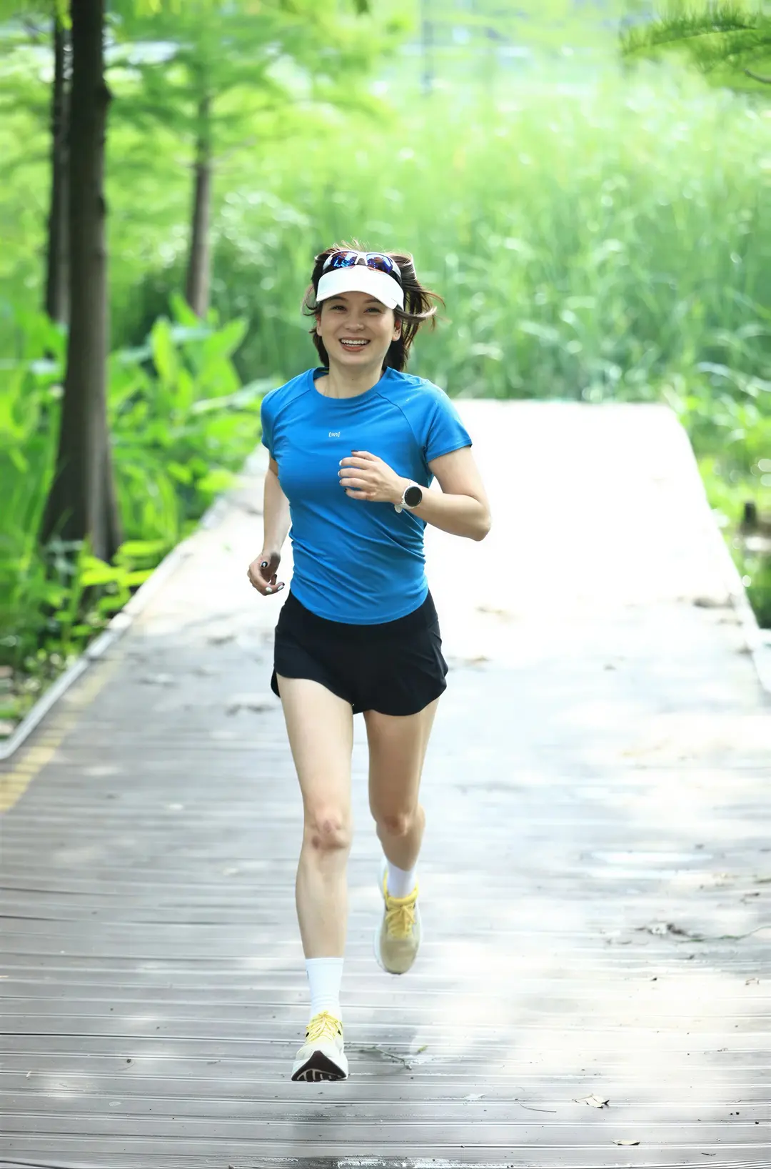 Alicia running through a vivid green landscape in electric blue