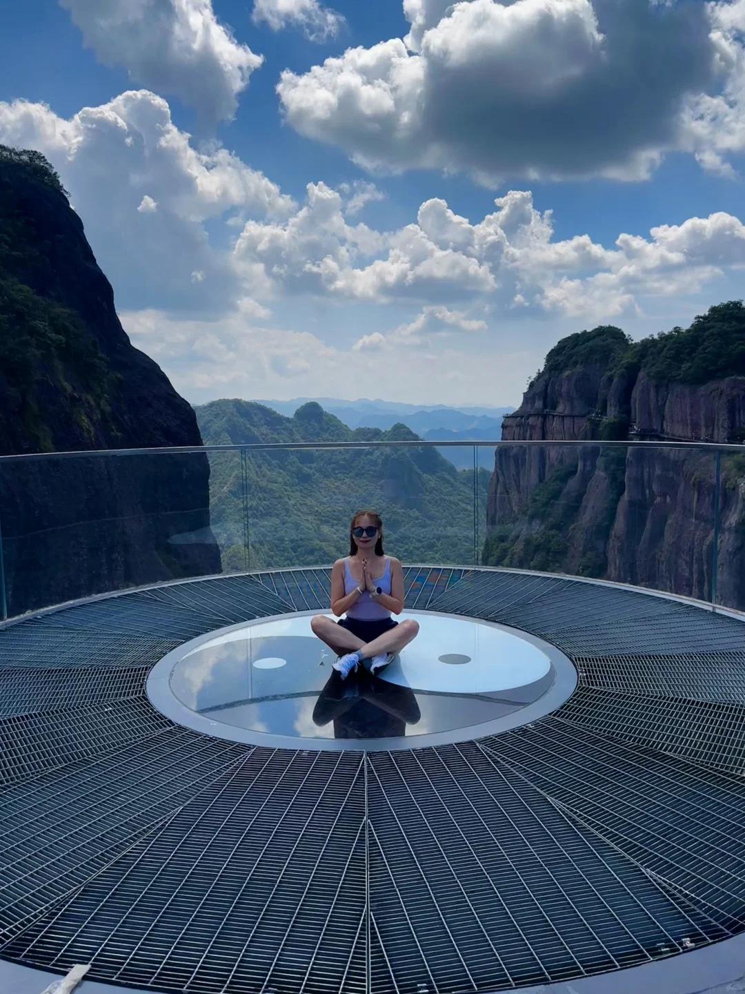 Alicia seated before a dramatic mountain landscape